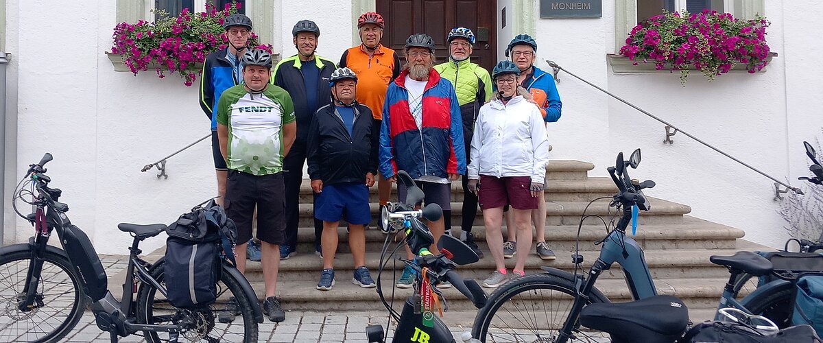 Neun Radfahrer mit Helmen stehen vor dem Rathaus Monheim, davor sind mehrere E-Bikes abgestellt. Auftakt zum Stadtradeln 2026 in Monheim