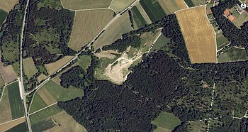 Luftaufnahme der Deponie Monheim:  Landschaft mit Feldern, Wäldern und einem unbebauten Gebiet in der Mitte.